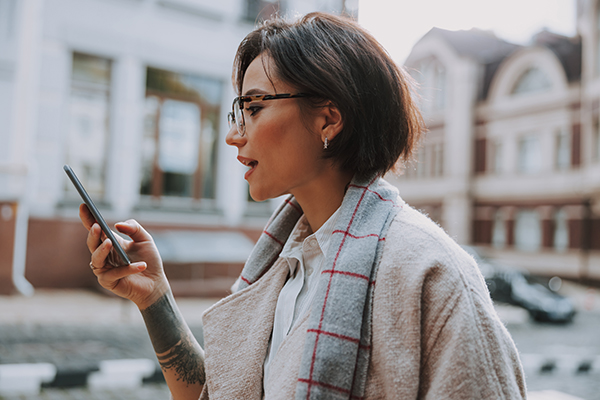 Waist up of pretty lady holding smartphone stock photo