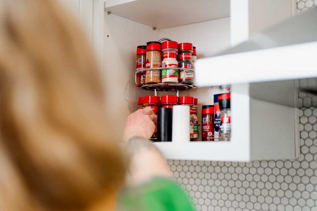 two-tiered rotating spice rack in a kitchen cabinet